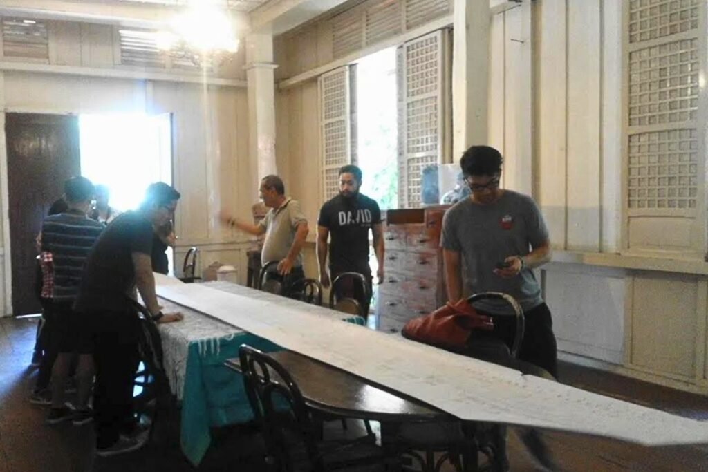 an Juan's grandchild and Balay ni Tan Juan Museum Director Clem del Castillo unfurls the scroll containing the family tree